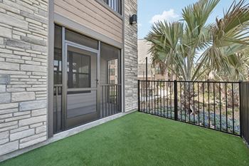 A patio with a black fence and a glass door.